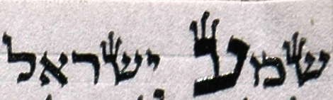 The opening words of the Shema' ("Hear, O Israel"; Deut. 6:8) from a mezzuzah parchment. The tagin ("crowns") are visible on the top left corners of the letters ש (far right), ע (the large letter in the middle) and ש (fourth letter from left). Photo courtesy of Wikimedia Commons.