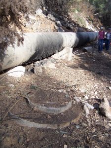 This manhole cover next to the water main shows where the sewer line disturbs the remains of the Roman road. Photographed by Joshua N. Tilton, November 12, 2016.