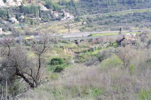 In the center of this photo is a highway bridge that now spans one of the tributaries of the Sorek Valley. Water flows down the narrow valley during the winter rainy season. A corner of Ramat Motza can be seen in the upper left of the photo. Photographed by Horst Krüger, February 2003.