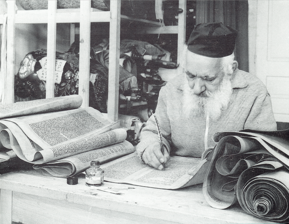 Modern Scribe with quill making repairs to a Torah scroll. (Courtesy of the Israel Government Press Office)